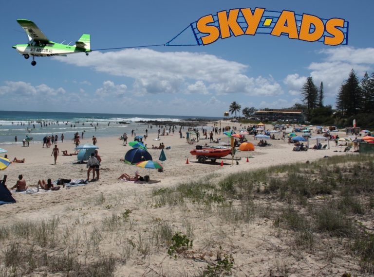sky-ads skywriting over crowded beach