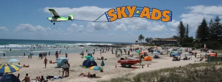 Crowded beach with SKY-ADS aircraft overhead