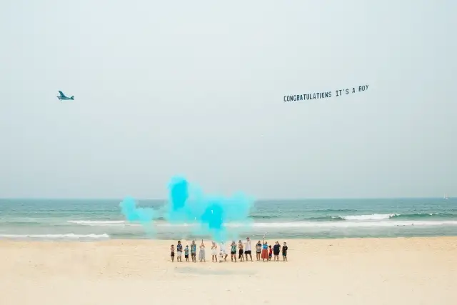 Banner flying over Beach gender reveal reads "Congratulations it's a Boy!"