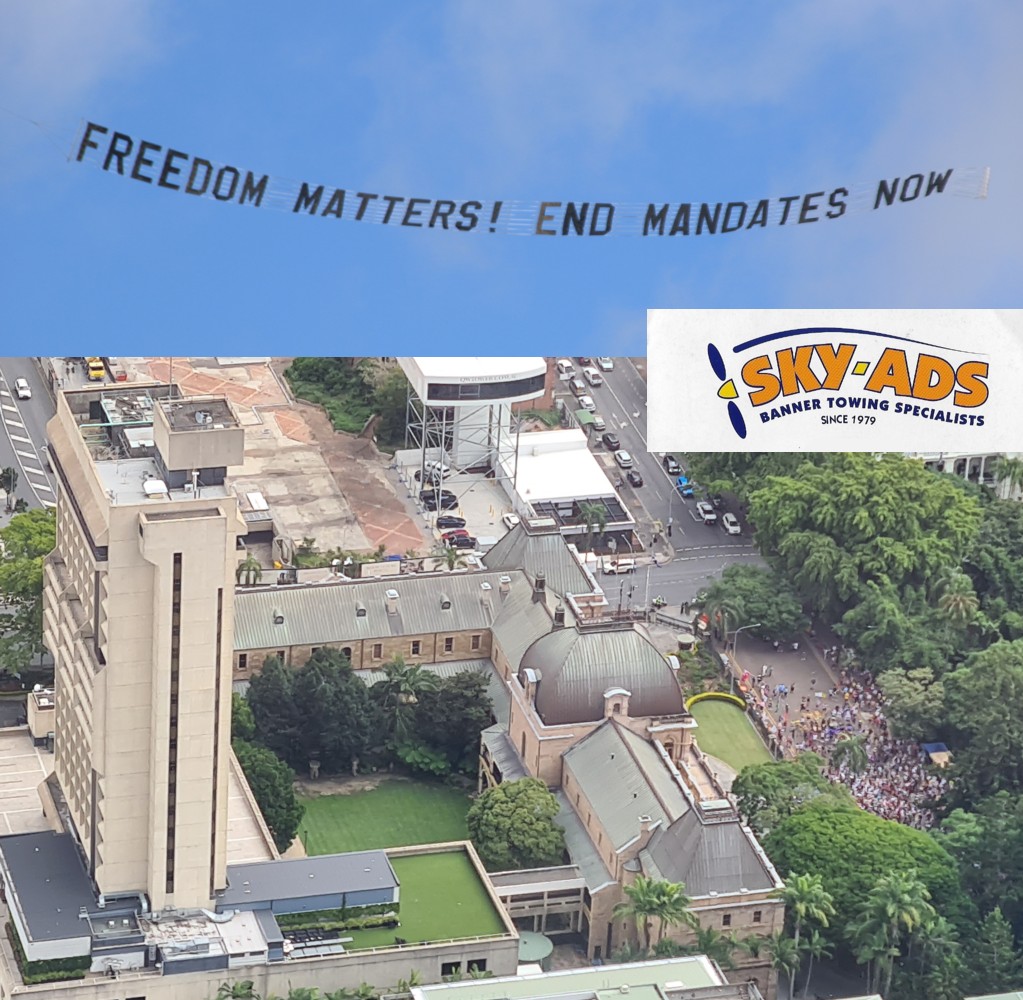 Sky Banner over protest reads "Freedom Matters! End Mandates Now"