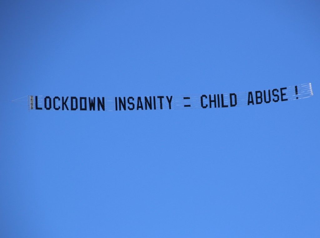 Protest Banner Reads "Lockdown insanity = Child Abuse"