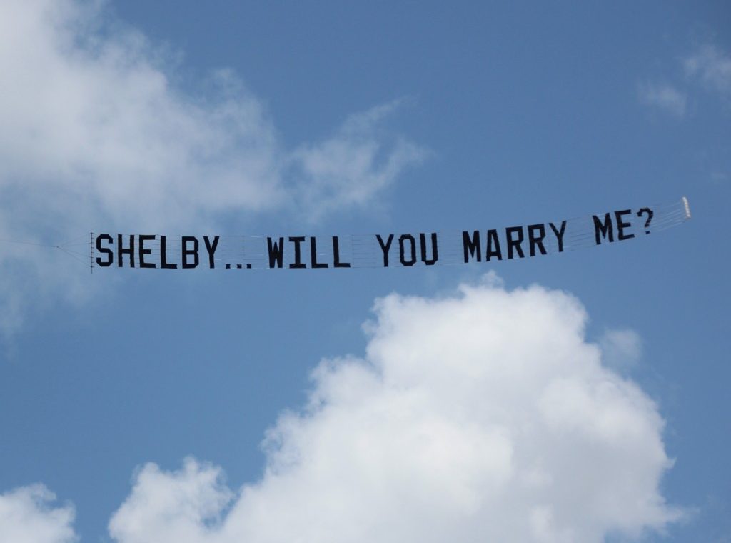 shelby will you marry me. showing on a banner behind a plane